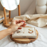 مجموعة bijou مرتبة بعناية على صينية محايدة مع إطلالة يومية أنيقة تحت إضاءة طبيعية