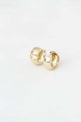 Two textured and smooth gold hoop earrings on white.