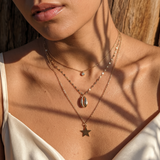 Collier trois rangs à pendentifs cauri, étoile et rond brillant